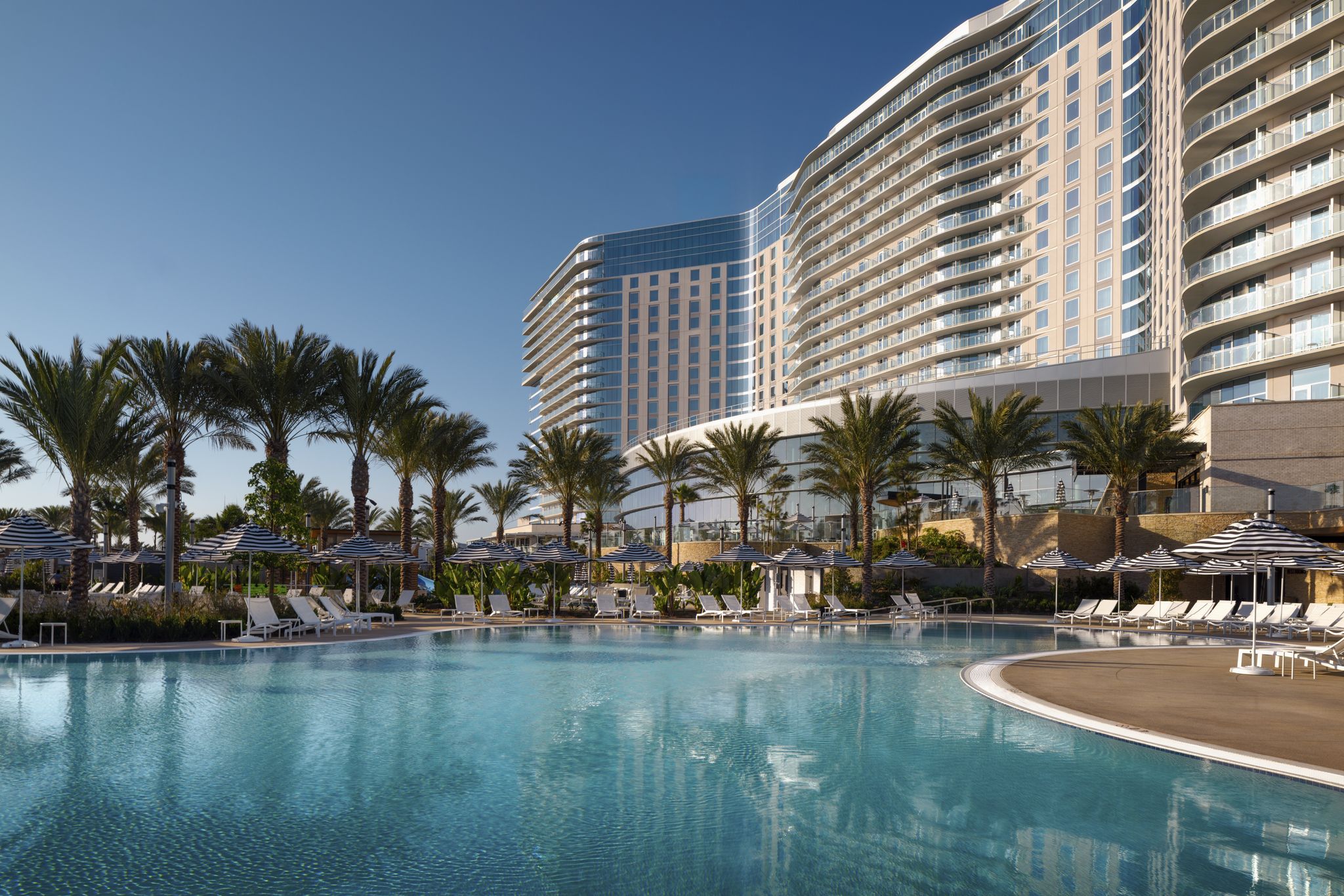 Gaylord Pacific family swimming pool with hotel balconies and poolside seating